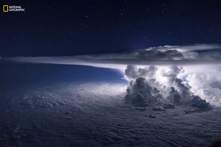 A colossal Cumulonimbus flashes over the Pacific Ocean as we circle around it at 37000 feet en route to South America