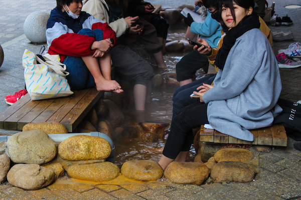 People sitting in an onsen in Arima Onsen